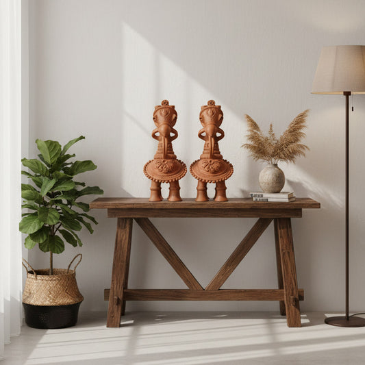 Handmade terracotta horse decor sculptures styled on a wooden table with plant and floor lamp for home interior styling.