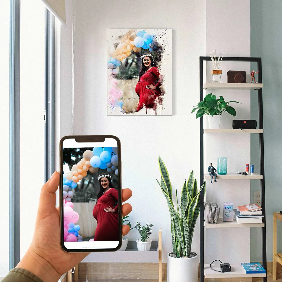 A custom watercolor portrait canvas featuring a smiling woman in a red dress standing next to a colorful balloon arch, displayed on a bright room wall beside a modern shelving unit. Free shipping by Incotta.