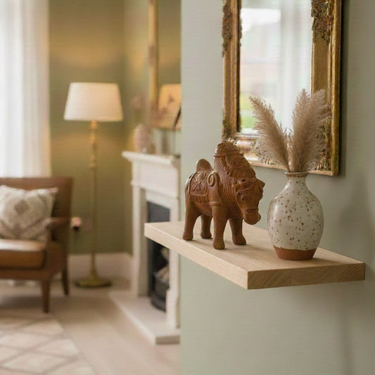 Rustic Indian terracotta elephant sculpture used as shelf decor, paired with neutral home accessories for interior styling.
