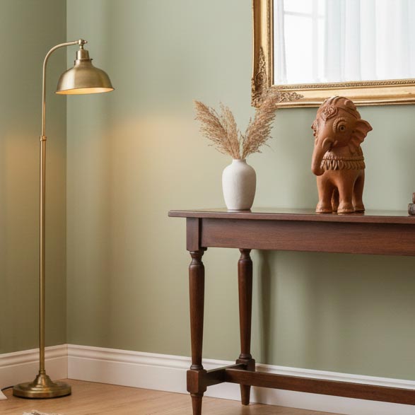 Handcrafted terracotta elephant figurine displayed on a wooden console table, styled with floor lamp and vase in a modern living room.