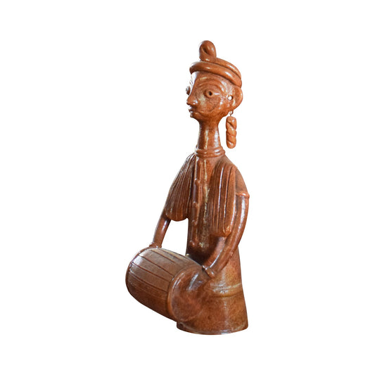Side view of a handcrafted terracotta brown doll playing a musical instrument, made in Panchmura, West Bengal