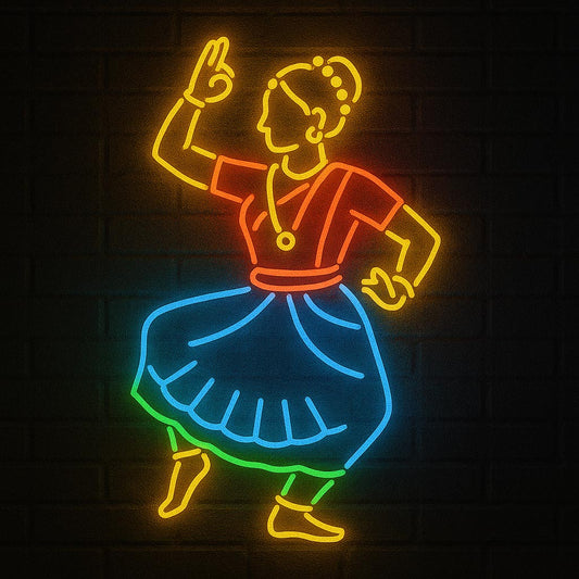 An illuminated LED neon sign depicting a traditional Indian classical dancer in a dynamic Bharatanatyam pose. The wall art features vibrant orange, red, and blue tubing against a dark brick background, perfect for cultural home decor or dance studios.