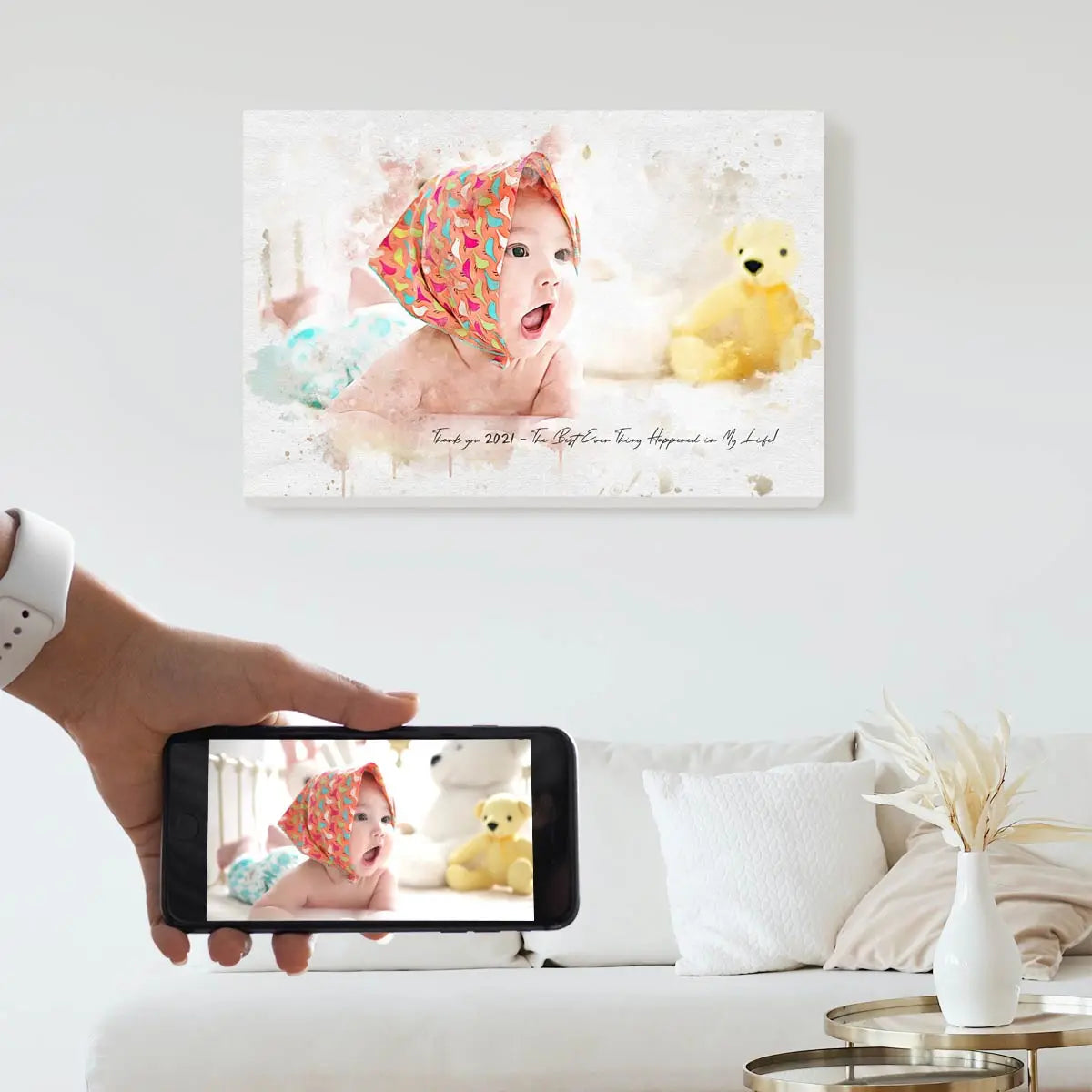 A custom watercolor portrait canvas featuring a smiling baby in a colorful headscarf next to a yellow teddy bear, displayed on a bright living room wall above a white couch. Free shipping by Incotta.