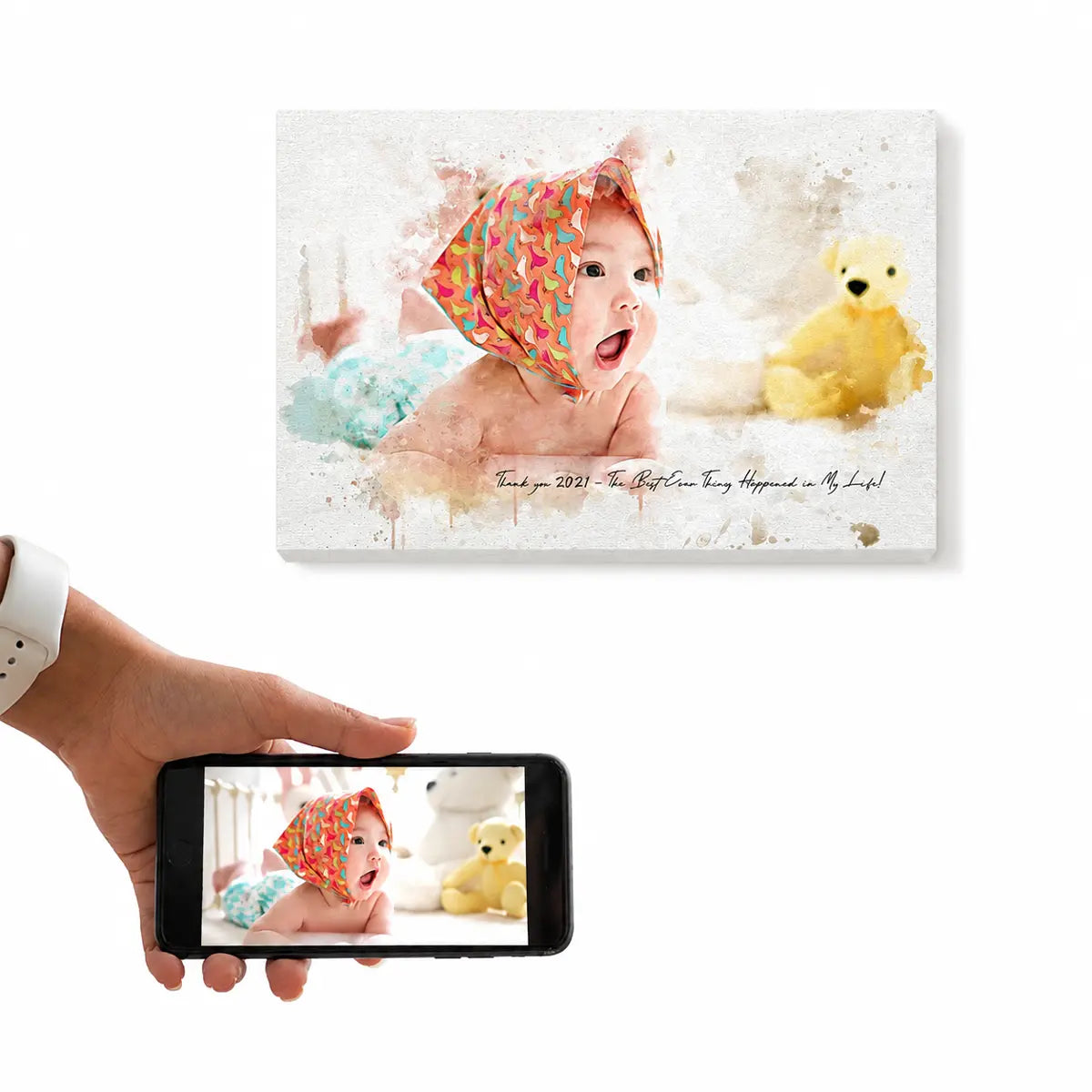 A customer holding a smartphone displaying a baby and teddy bear photo next to the resulting custom watercolor baby portrait canvas. Free shipping by Incotta.