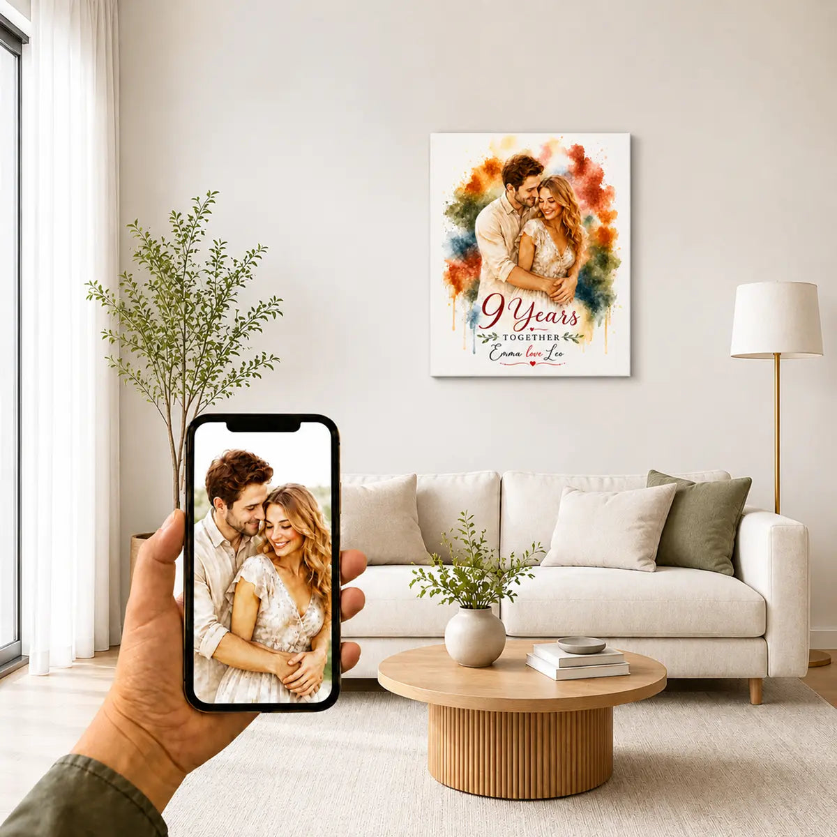A custom watercolor couple portrait canvas celebrating an anniversary, featuring a smiling man and woman embracing, displayed on a modern living room wall above a white sofa and round wooden coffee table. Free shipping by Incotta.