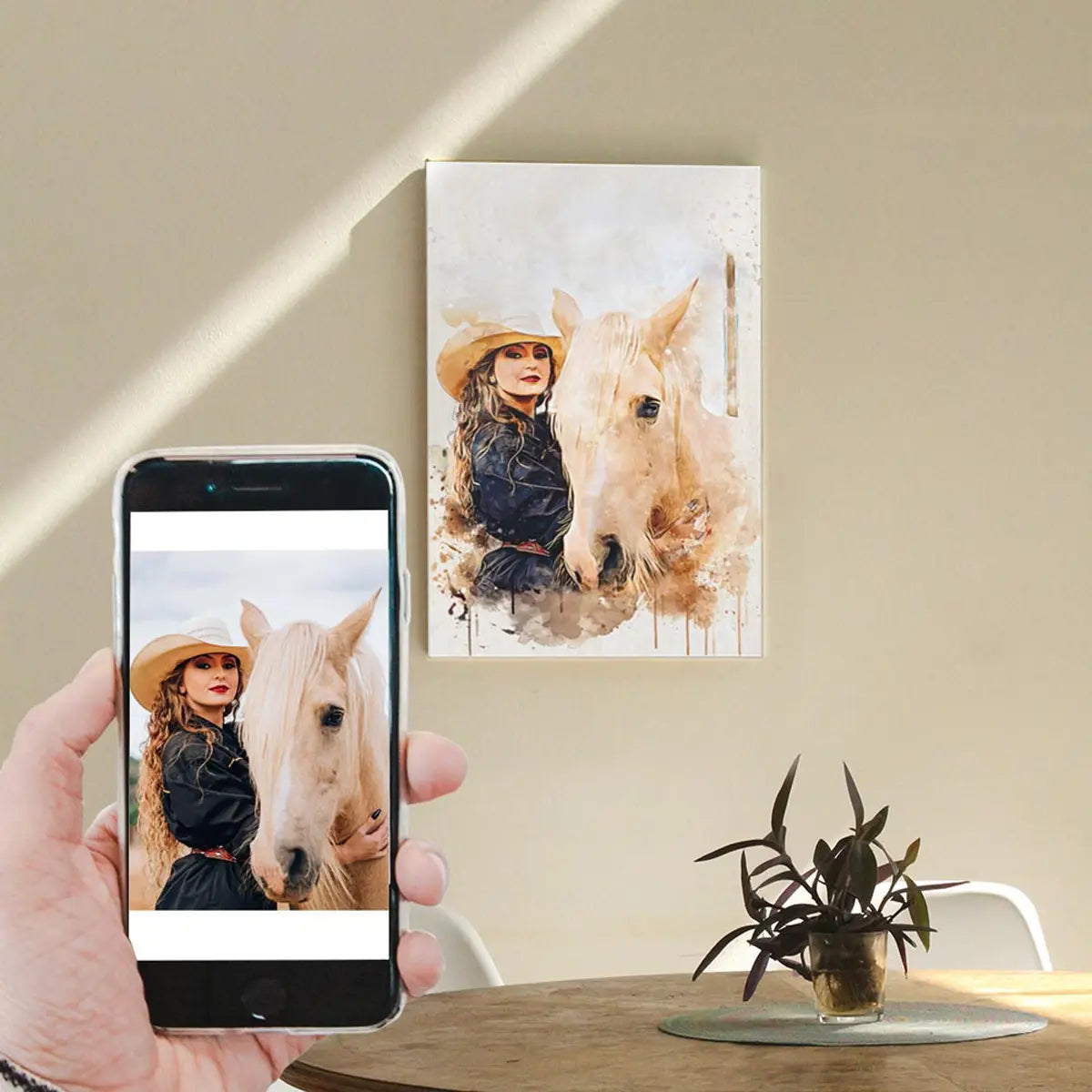 A custom watercolor portrait canvas featuring a woman in a cowboy hat and her light-colored horse, displayed on a sunlit living room wall above a wooden table. Free shipping by Incotta.