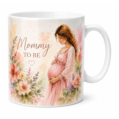 A beautifully customized glossy white ceramic coffee mug featuring a delicate watercolor portrait of an expecting mother in a pink dress, surrounded by pastel spring flowers and "Mommy TO BE" text.