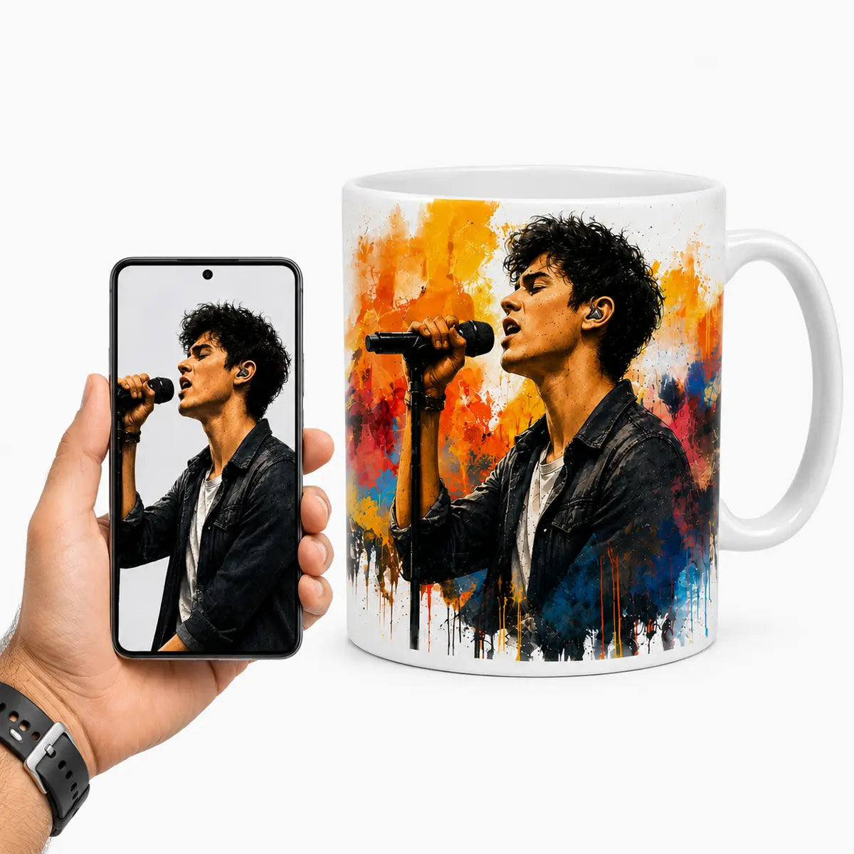 A custom watercolor portrait mug featuring a male singer performing with a microphone against vibrant orange and blue splashes, displayed next to a hand holding a smartphone with the original reference photo. Free shipping by Incotta.