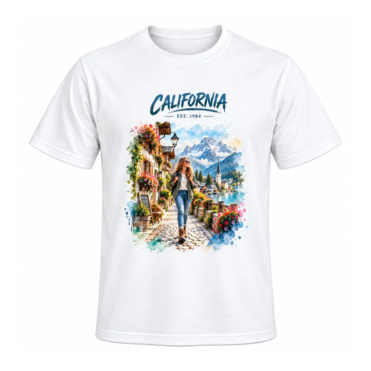 A white custom watercolor vacation destination graphic tee featuring a personalized alpine mountain village landscape and a female traveler. Free shipping by Incotta.
