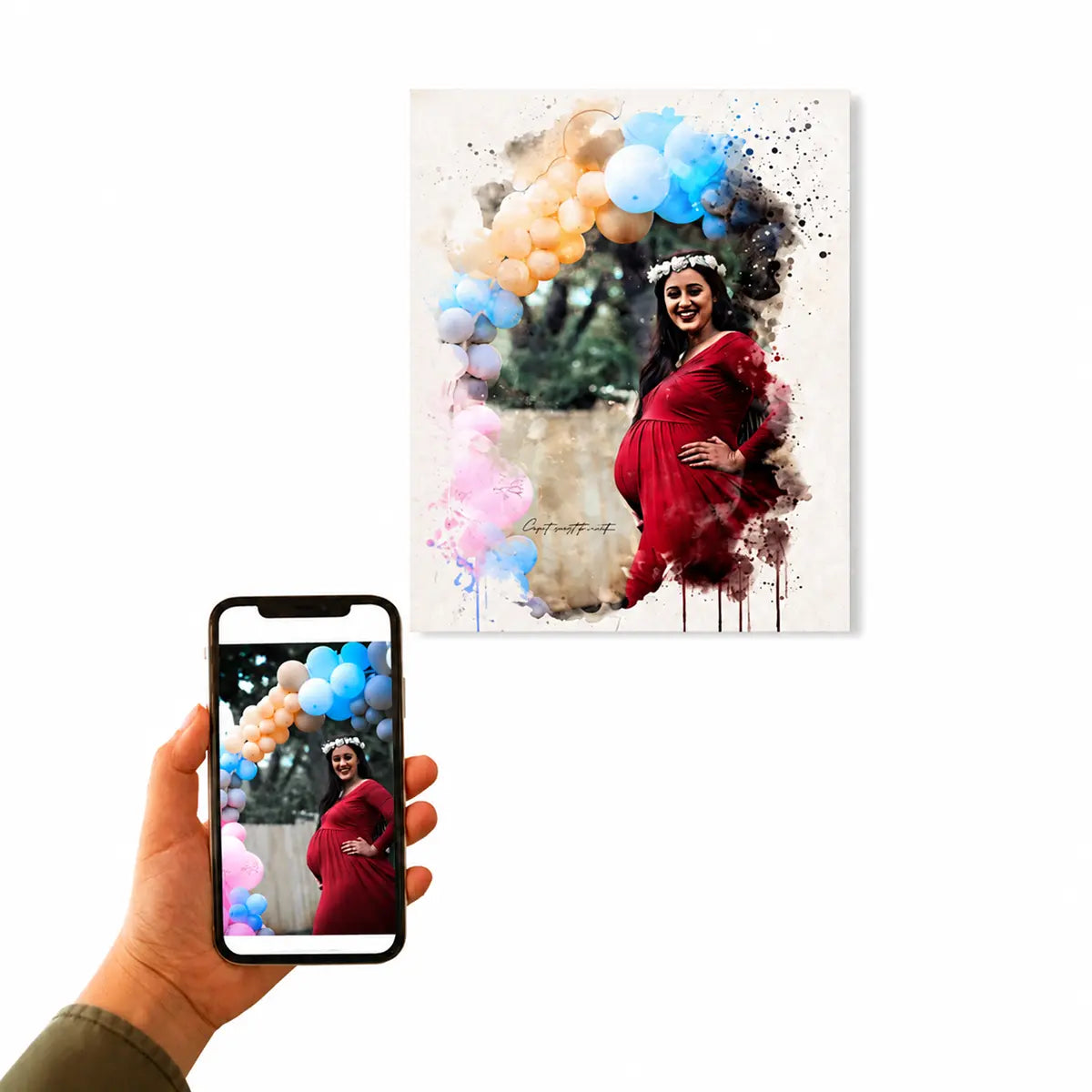 A customer holding a smartphone displaying a pregnant woman in a red dress by a balloon arch next to the custom watercolor baby shower portrait canvas. Free shipping by Incotta.