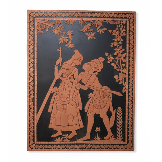 Handcrafted Indian wall art depicting Radha and Krishna in traditional folk style, terracotta tones on black background.