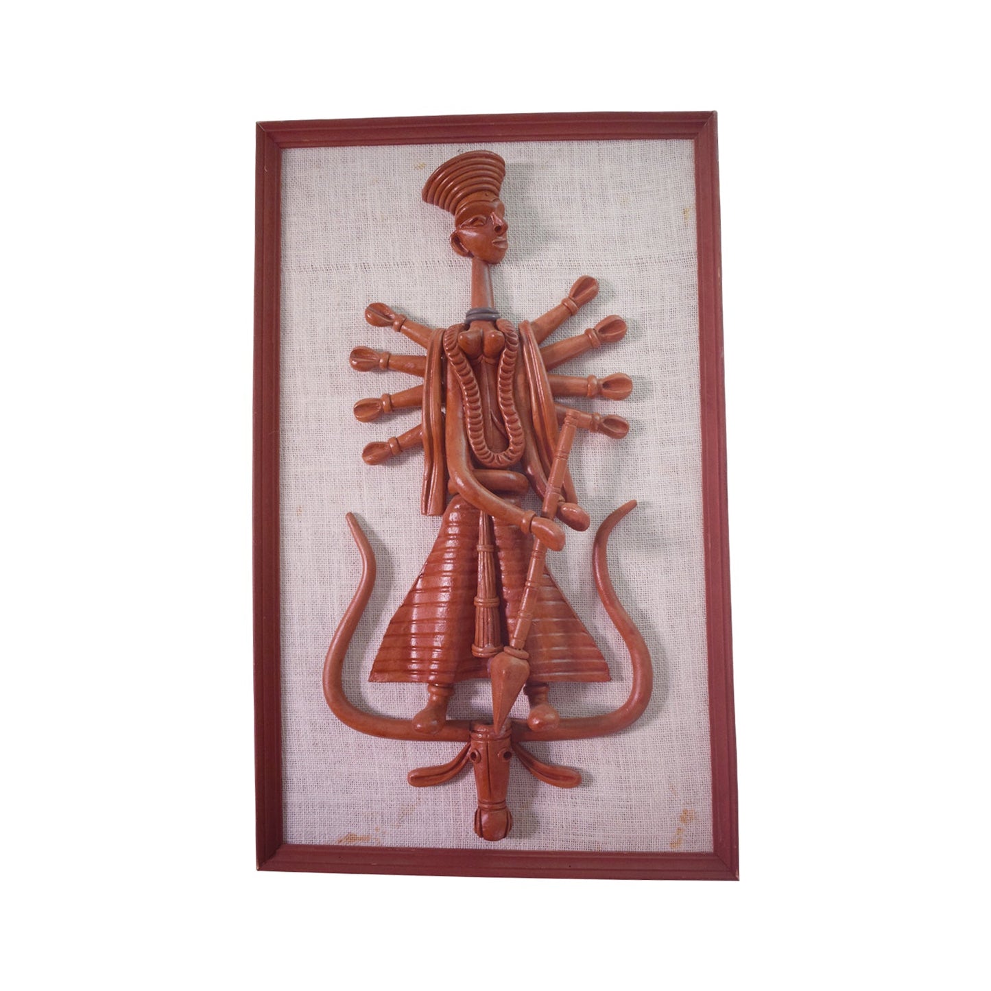 Front view of a framed terracotta wall hanging depicting the Goddess Durga in a stylized, multi-armed form, standing atop a vehicle figure. The reddish-brown clay sculpture is mounted on a textured fabric backing, representing traditional Panchmura folk art craftsmanship.
