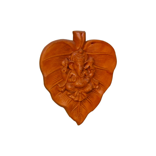 A front view of a handcrafted terracotta wall hanging featuring Lord Ganesha seated within a stylized leaf motif (resembling a Betel or Peepal leaf). This traditional clay sculpture showcases intricate relief detailing of the deity and leaf veins, finished in a natural reddish-brown earthenware tone against a white background.