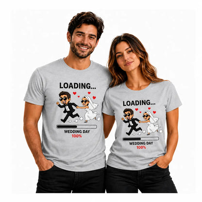 Couple wearing matching grey T-shirts featuring a playful wedding loading design with a running bride and groom, hearts, and “Wedding Day 100%” graphic.
