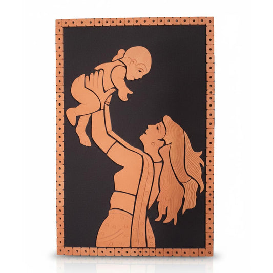 A handcrafted terracotta wall hanging portraying a mother joyfully lifting her baby in the air. The 3D relief sculpture is created from reddish-brown clay and mounted on a black rectangular board framed by a decorative border of clay beads, showcasing traditional Indian folk art.