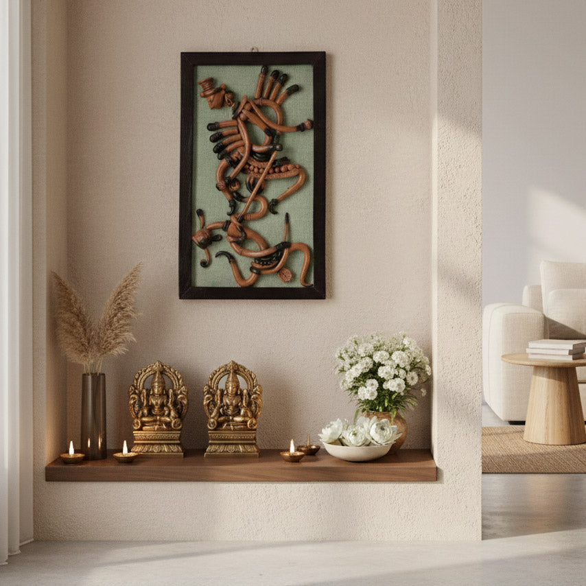 Handcrafted Indian tribal dancer wall decor displayed in a spiritual corner with brass idols, candles, and floral accents.