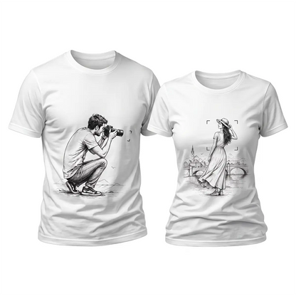 Two white t-shirts displayed side-by-side: left has a sketch of a crouching photographer, right has a sketch of a woman posing with a cityscape and bridge.