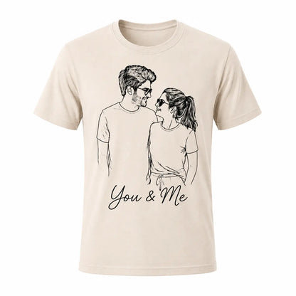 A beige natural color unisex t-shirt featuring a custom minimalist line art portrait of a smiling couple. Perfect for personalized anniversary gifts. Free shipping by Incotta.