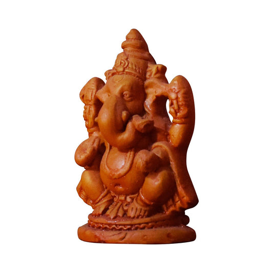 A clear side-angle studio shot of a handcrafted eco-friendly terracotta Lord Ganesha statue isolated on a white background. The clay idol features intricate detailing on the headdress and trunk, seated on a round base, showcasing traditional Indian artistry.