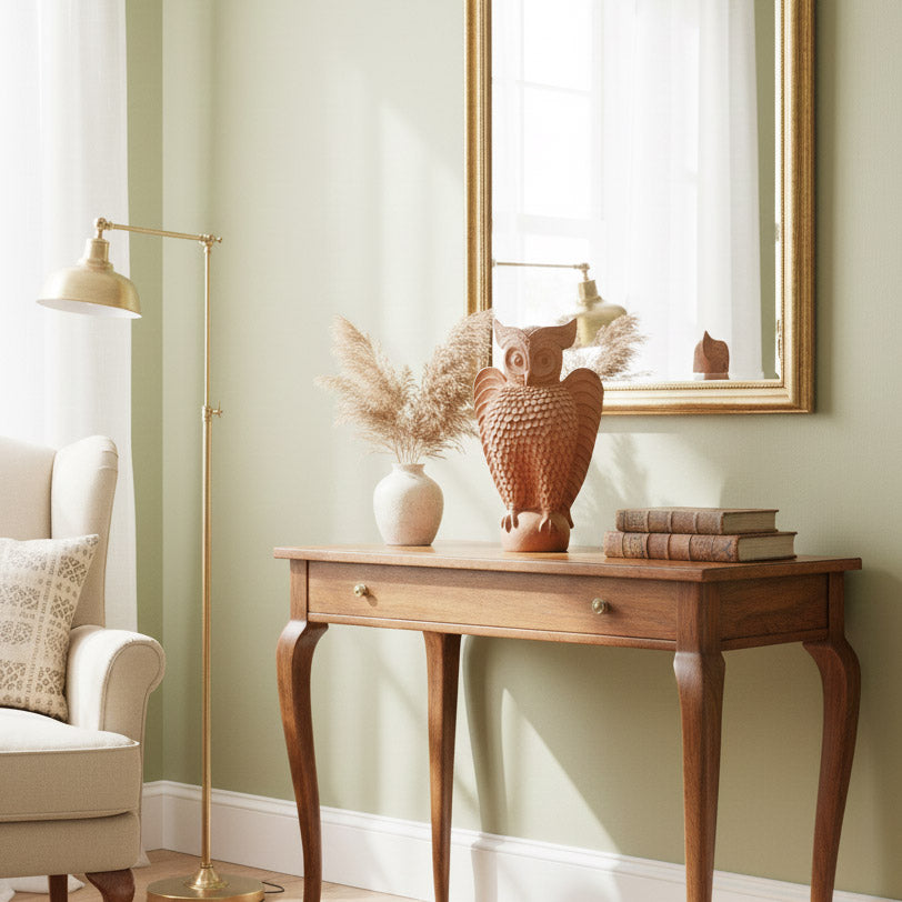 Indian terracotta owl decor placed on a console table with mirror and floor lamp, showcasing handcrafted pottery in a cozy interior.